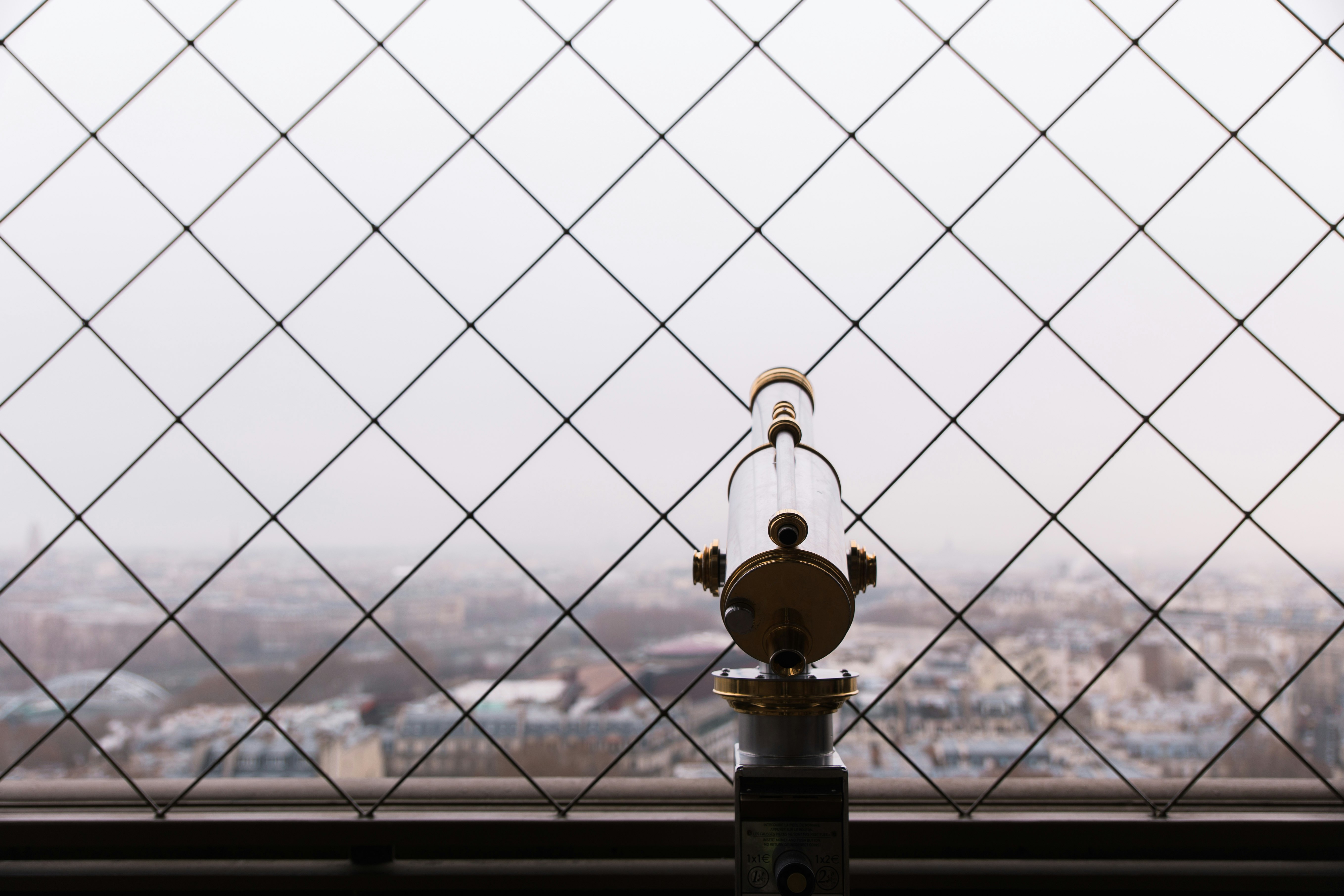 gray and brass-colored telescope facing city buildings